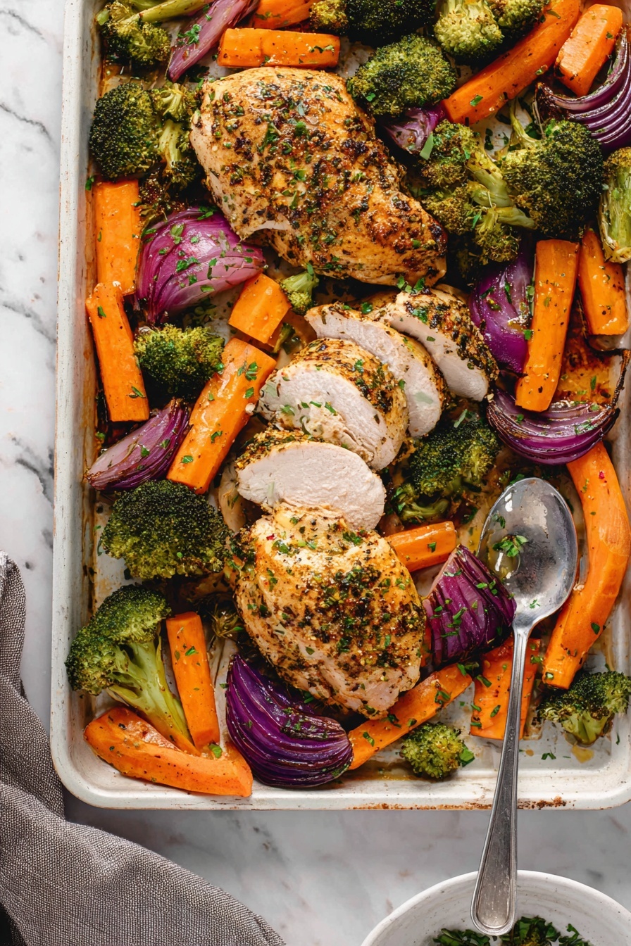 The image shows a baking tray filled with four cooked chicken pieces, golden brown with herbs sprinkled on top. The chicken pieces are surrounded by thick orange carrot sticks, bright green broccoli florets, and wedges of red onion, all roasted with a slightly charred texture. One chicken piece at the bottom right is sliced into thick, even pieces, showing the juicy white inside. A silver serving spoon is resting on the tray among the vegetables. The tray is placed on a white marbled surface with a teal cloth partially visible on the bottom right, and a small white bowl with green herbs can be seen at the edge. photo taken with an iphone --ar 2:3 --v 7