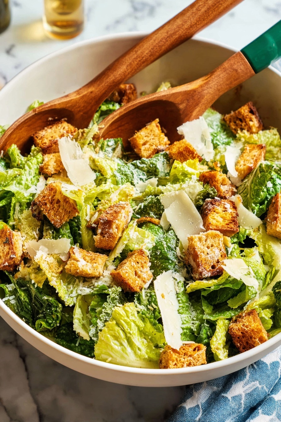 A large white bowl sits on a white marbled surface, filled with a fresh Caesar salad. The salad has layers of crisp, bright green romaine lettuce pieces mixed with golden-brown toasted croutons. Scattered across the top are thin, off-white shavings of Parmesan cheese. Two wooden salad servers with green-painted handles rest inside the bowl, ready to toss the salad. In the background, there is an empty white plate with three silver forks stacked on it, and to the right, a glass being filled with pale yellow white wine from a green bottle next to a blue patterned cloth napkin. Photo taken with an iphone --ar 2:3 --v 7