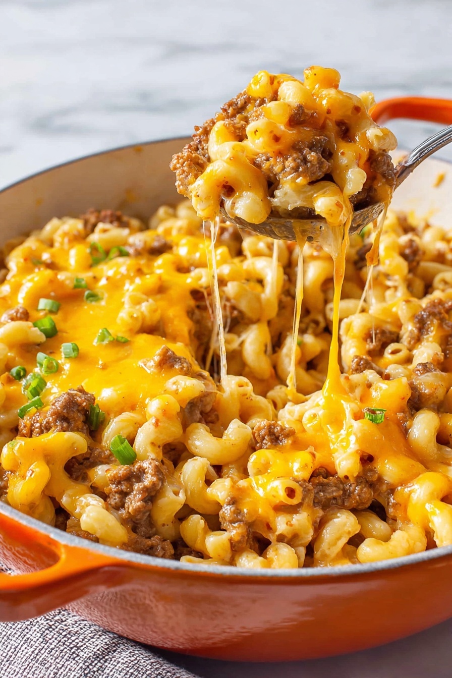 The image shows a close-up of a pot filled with macaroni pasta mixed with browned ground beef and melted bright orange cheddar cheese. The top layer is covered with a thick stretch of melted cheese that forms strings as a spoon lifts a serving from the pot. Scattered small bits of green onion add spots of fresh green color on top. The pot is white inside with orange handles, sitting on a white marbled surface. The overall look is warm, cheesy, and hearty, with a mix of creamy, browned, and slightly crispy textures. photo taken with an iphone --ar 2:3 --v 7