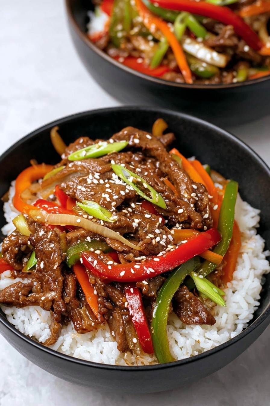 A black bowl holds a bed of white rice as the bottom layer, topped with sizzling strips of dark brown beef mixed with colorful bell pepper slices in red, green, yellow, and orange, along with pieces of translucent onion and green onion. The beef and vegetables are coated in a shiny sauce, and the dish is sprinkled with white sesame seeds. Behind this bowl, part of a second bowl with similar contents is visible. Both bowls sit on a white marbled surface. photo taken with an iphone --ar 2:3 --v 7