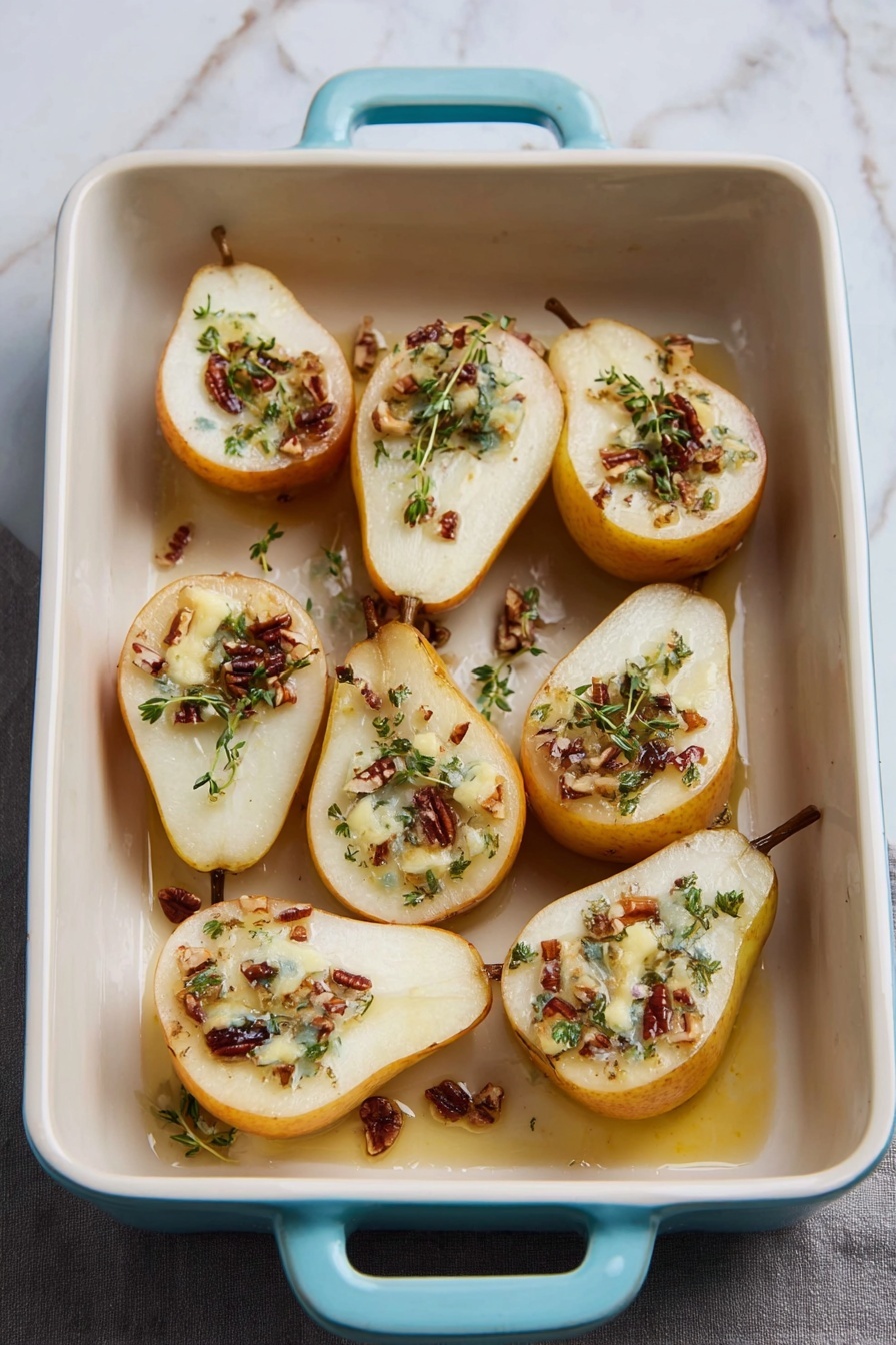 The image shows eight halves of baked pears arranged in a white rectangular dish with pale blue handles. Each pear half is light yellow with a slightly soft texture, filled in the hollow center with small pieces of brown nuts, melted white cheese, and fresh green herb leaves. Sweet syrup or melted butter pools lightly around the pear bases inside the dish. The dish is set on a white marbled surface, with a pear and some green herbs blurred in the background. photo taken with an iphone --ar 2:3 --v 7