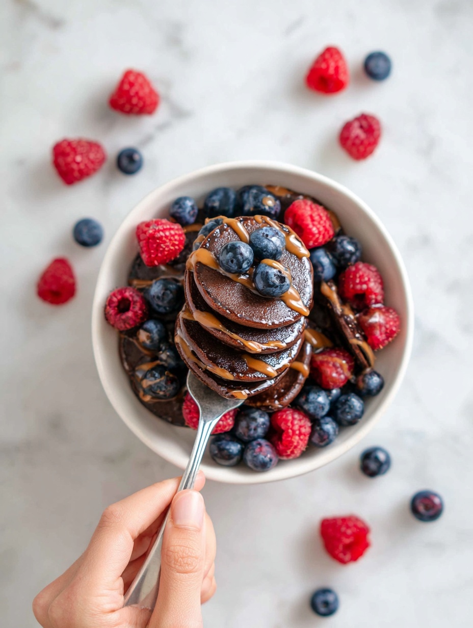 Inside a clear blender container seen from above, there are visible layers of ingredients waiting to be mixed. The base layer has a light brown powder and some white flour lightly dusted on top. In one corner, soft yellow banana pieces lay beneath a sprinkle of brown cocoa powder and some oats peeking through. Another part shows creamy white yogurt, partly covered with cocoa powder. The blender’s sharp metal blades cross in the center, ready to blend the contents. The container is placed on a white marbled surface. Photo taken with an iphone --ar 2:3 --v 7