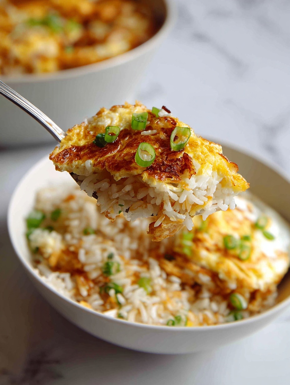 The image shows a close-up of a spoon holding a mix of cooked white rice along with a fried egg. The egg has a golden crispy edge and a soft, runny yolk that is bright orange-yellow. Small pieces of chopped green spring onions are scattered on both the rice and egg, adding a fresh green color. The rice looks soft and slightly shiny, suggesting it’s mixed with some sauce or oil. The spoon is just above a white bowl with blue stripes inside, filled with more rice and parts of the fried egg visible. The background is a white marbled texture. Photo taken with an iphone --ar 2:3 --v 7