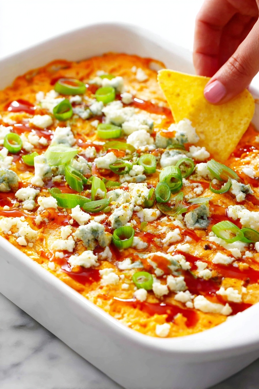 A clear glass bowl filled with a creamy, chunky orange mixture that has visible small green bits scattered throughout. The texture looks thick and slightly rough with soft lumps. A red and black spatula is resting inside the bowl, partly covered in the mixture. The bowl sits on a white marbled surface. Photo taken with an iphone --ar 2:3 --v 7